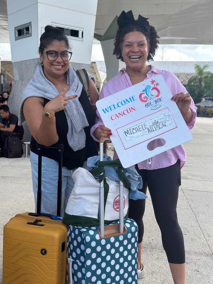 Happy travelers welcomed at Cancún Airport by Go Holbox Shuttle with a personalized sign